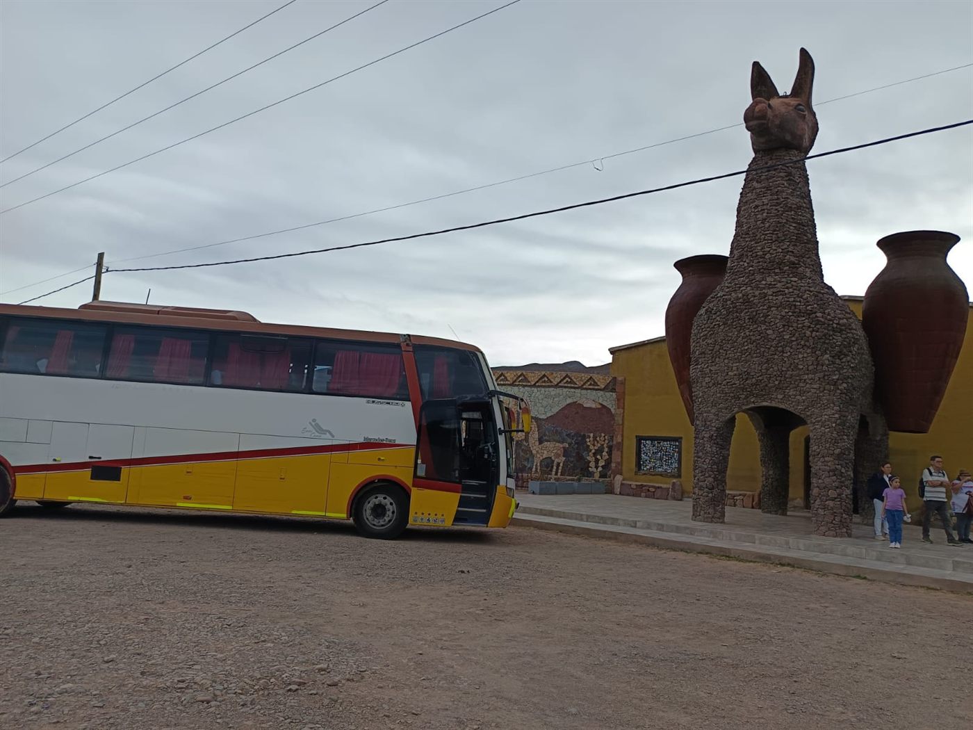 Bus TransKadise junto a esculturas de llamas